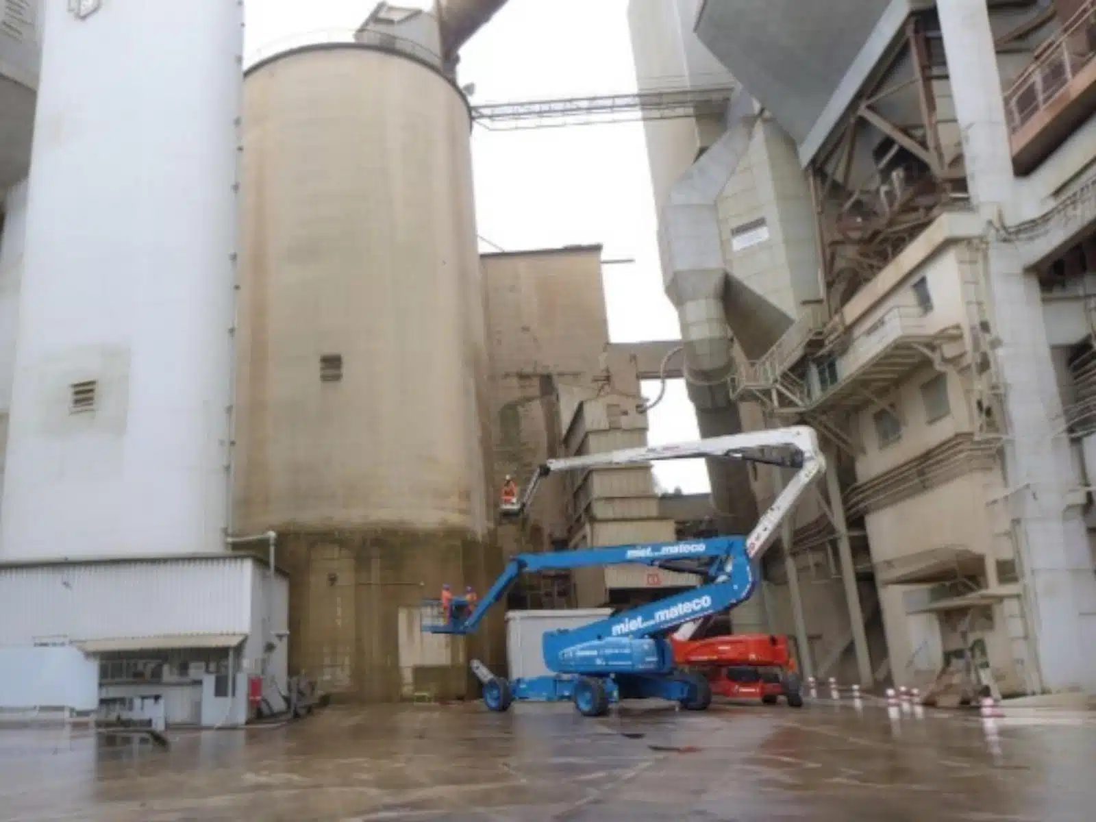 Panoramic view of cement plant with four silos undergoing robotic inspection