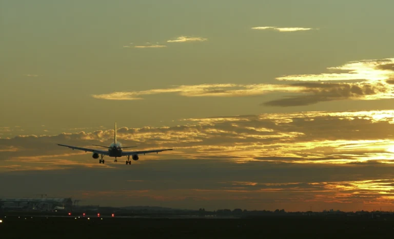 A plane lands at sunset at Heathrow Airport